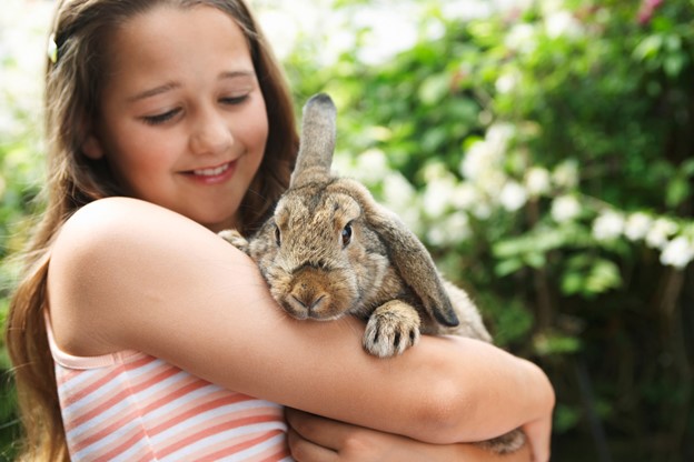 Little girl holding the rabbit.