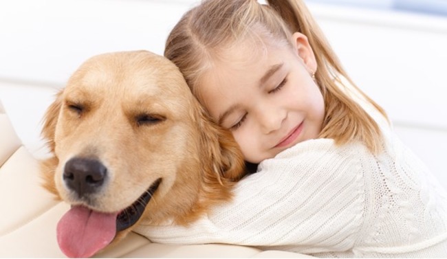 Little girl hugging her dog.